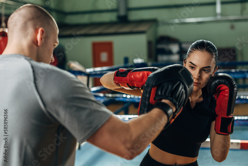 Pretty young woman trains in boxing ring with partner © cherryandbees
