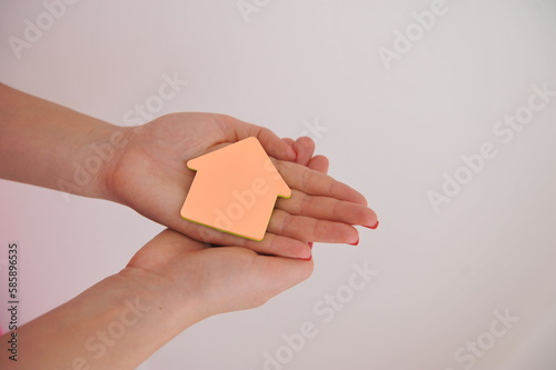 mãos segurando casa, aquisição da casa própria, negócios imobiliarios 