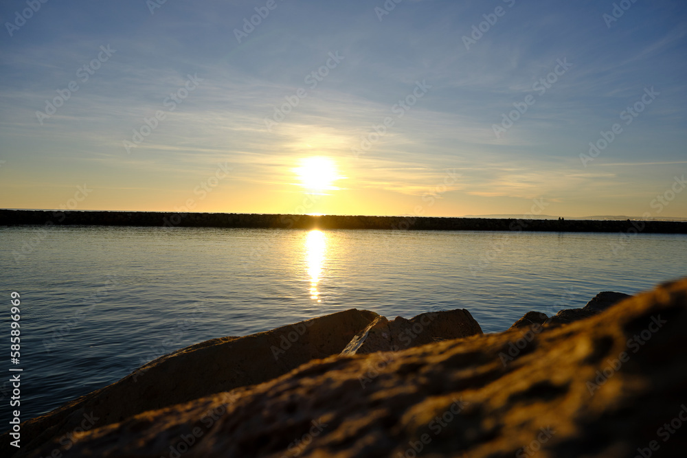 sunset at the sea in front of a dike