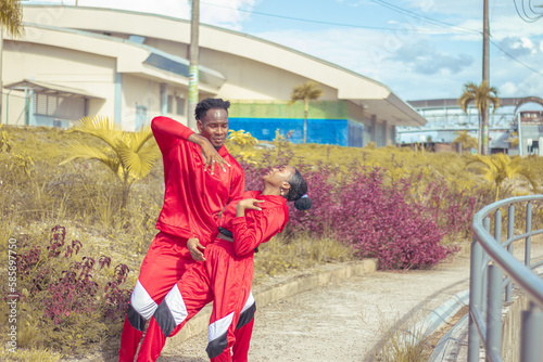 Pareja de bailarines afro realizan actuacion de baile en parque con hermosa vegetacion y hermoso cielo azul photo