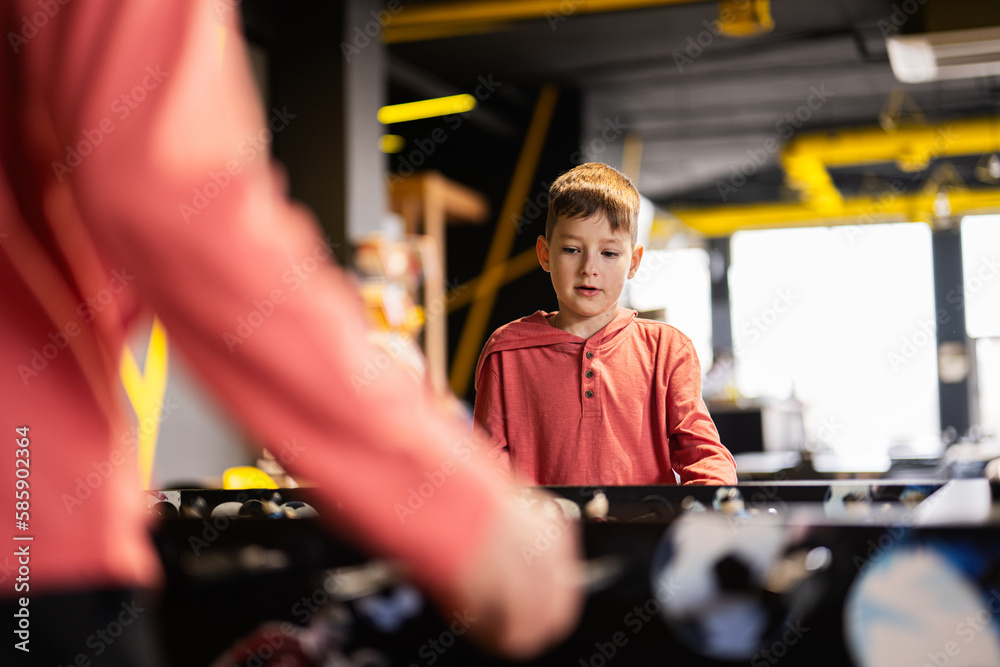 Brothers playing table football in kids play center. Brothers playing table football in kids play center.