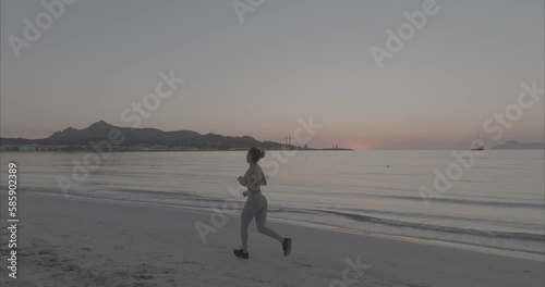 Mujer corriendo por la playa con amanecer y atardecer (Video LOG para corrección de color profesional)
