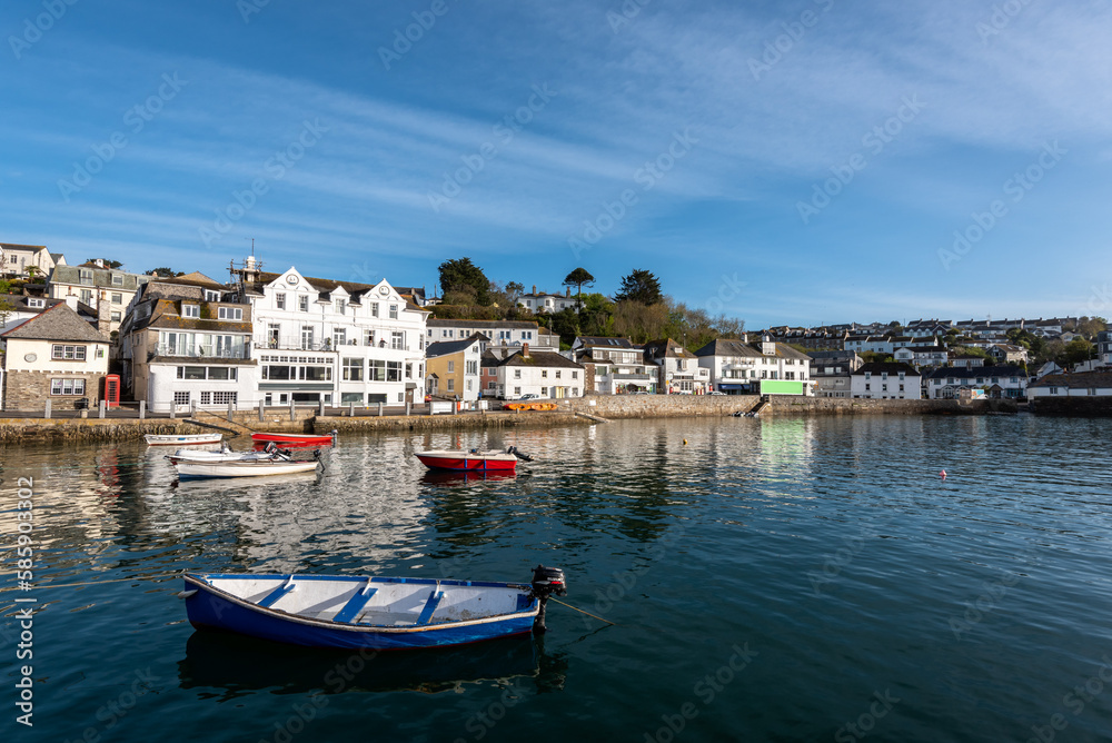 View of the pretty historic Cornish fishing village of Polperro with the harbour, fishing boats and fishermans cottages in sunshine