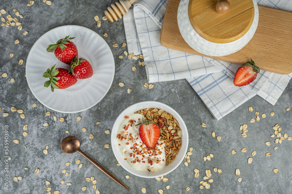 Healthy food concept: homemade granola with yogurt and strawberries. Oatmeal with freeze-dried strawberries, fresh berries and honey. Delicious and healthy breakfasts, top view