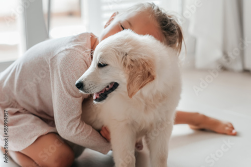 child girl play hugging dog puppy golden retriever, pet therapy and canisterapy for adults and children. animal canis assisted therapy. kids emotion mental health friends love tightly cuddle