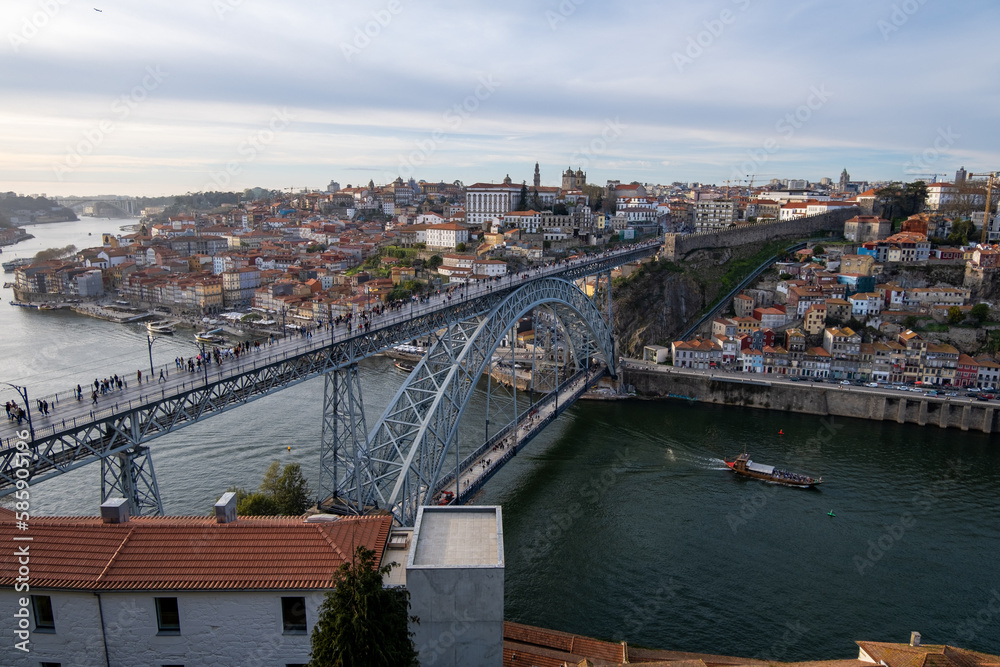 Imagen desde lo alto del puente de Don Luis I en Oporto con la ciudad al fondo bajo un cielo nublado de primavera.