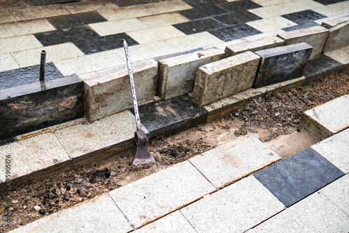 The metal pipe is welded to the axe. Repair of the sidewalk from tiles.