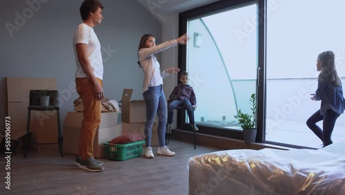 Mixed race family moving into their new home. They're unpacking and having fun together.	
