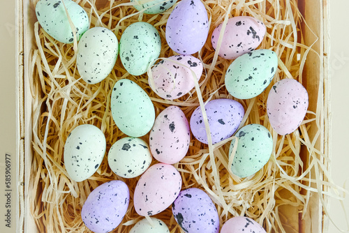 Basket of colored Easter eggs on a white background. Close Up. Top View. Space for text, banner