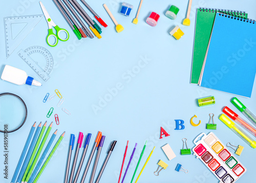 Stationery, notepads, paints, felt-tip pens, markers with place for text on a blue background.