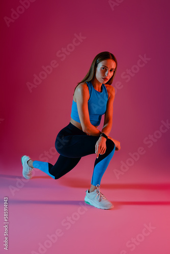 Sporty woman stretching her legs in studio before sports training or workout. High quality photo