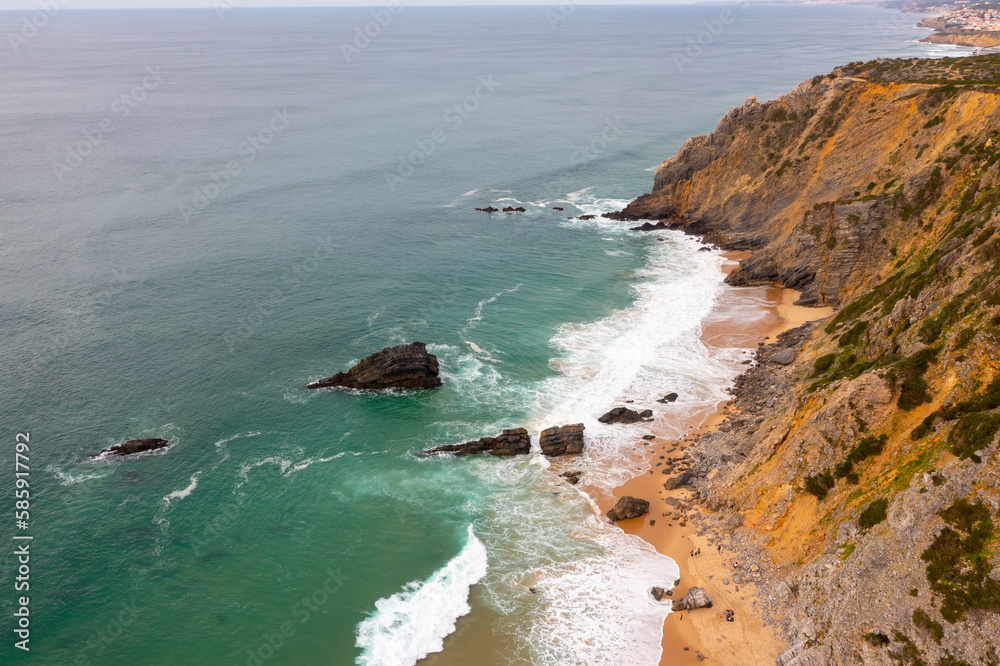 Aerial view of rocky cliff coastline with ocean waves