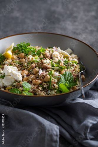 Bild auf Leinwand Healthy Salad made from Quinoa, Cucumber, Herbs, Pistachios, Chickpeas and Feta with lemon juice and olive oil