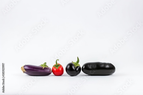  a group of three different types of vegetables on a white background with a black eggplant and a red eggplant in the middle.  generative ai