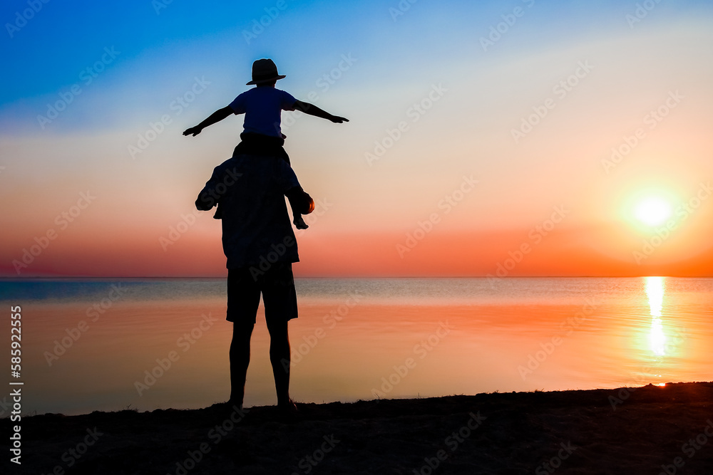 A Happy parent with child by the sea play on nature silhouette travel