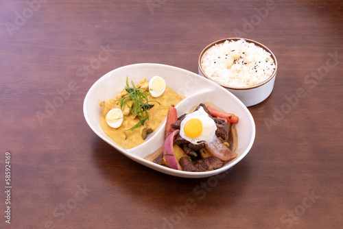 Tray of Peruvian mixed plate of lomo saltado, aji de gallina and white rice
