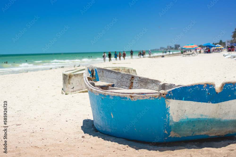 Toma de una playa con un par de botes pesqueros y personas irreconocibles a lo lejos, arena blanca, mar del caribe Toma de una playa con un par de botes pesqueros y personas irreconocibles a lo lejos, arena blanca, mar del caribe