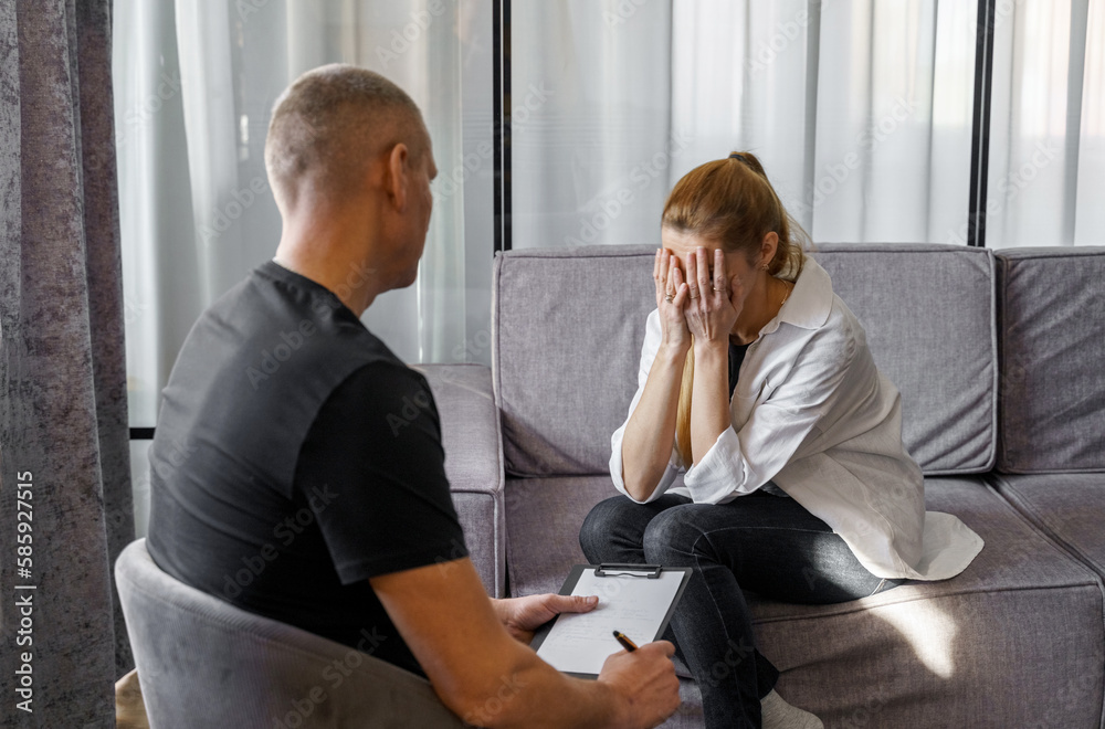 A male psychologist consults a female patient, makes notes. A male psychologist consults a female patient, makes notes.