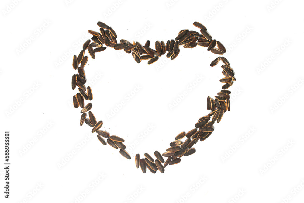 Sunflower seeds in the shape of a heart on white background. Sunflower seeds in the shape of a heart on white background.