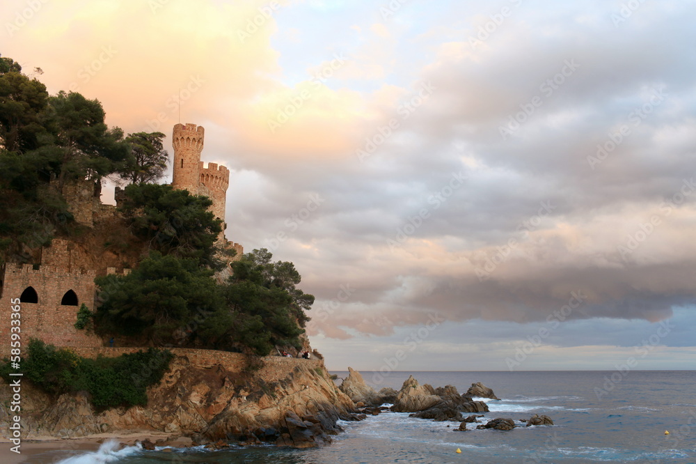 ancient fortress with towers on a rocky seashore, low clouds, rocks, seascape