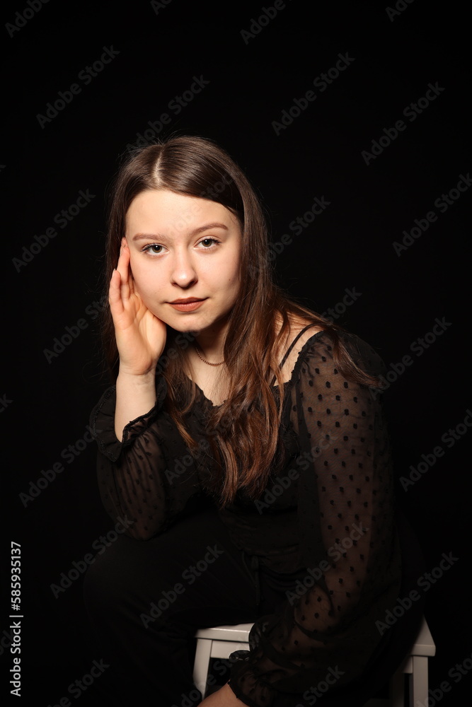 portrait of a beautiful young brunette woman in a black blouse on a black background. strict portrait of a girl on a black background portrait of a beautiful young brunette woman in a black blouse on a black background. strict portrait of a girl on a black background