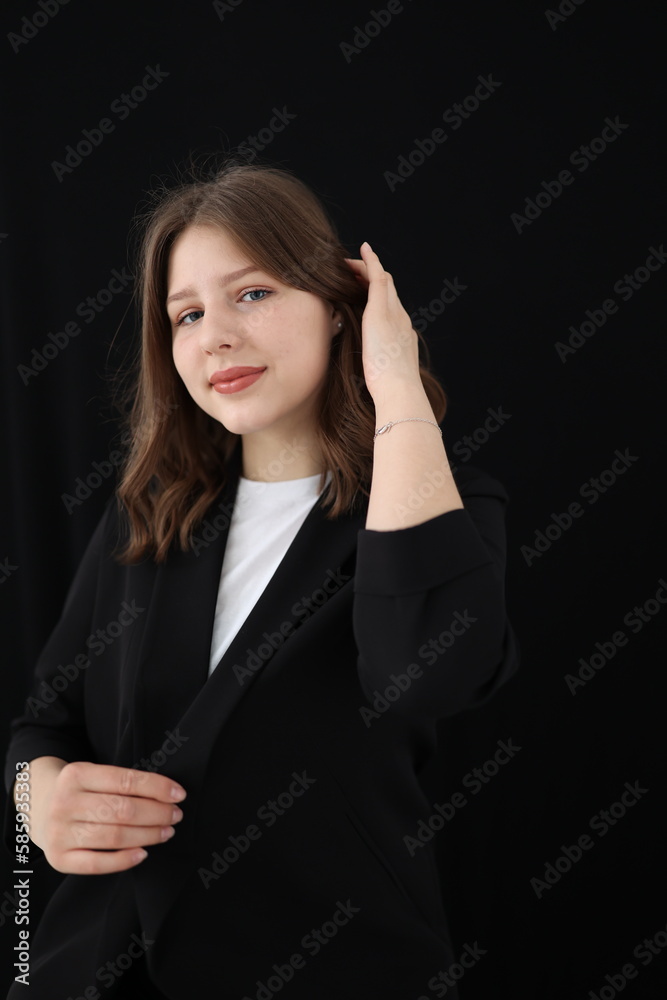 portrait of a beautiful young brunette woman in a black blouse on a black background. strict portrait of a girl on a black background portrait of a beautiful young brunette woman in a black blouse on a black background. strict portrait of a girl on a black background