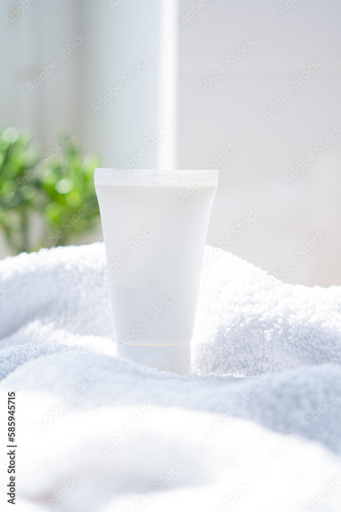 White cream tube and towel in real room interior mock-up, beauty and care product packaging template White cream tube and towel in real room interior mock-up, beauty and care product packaging template