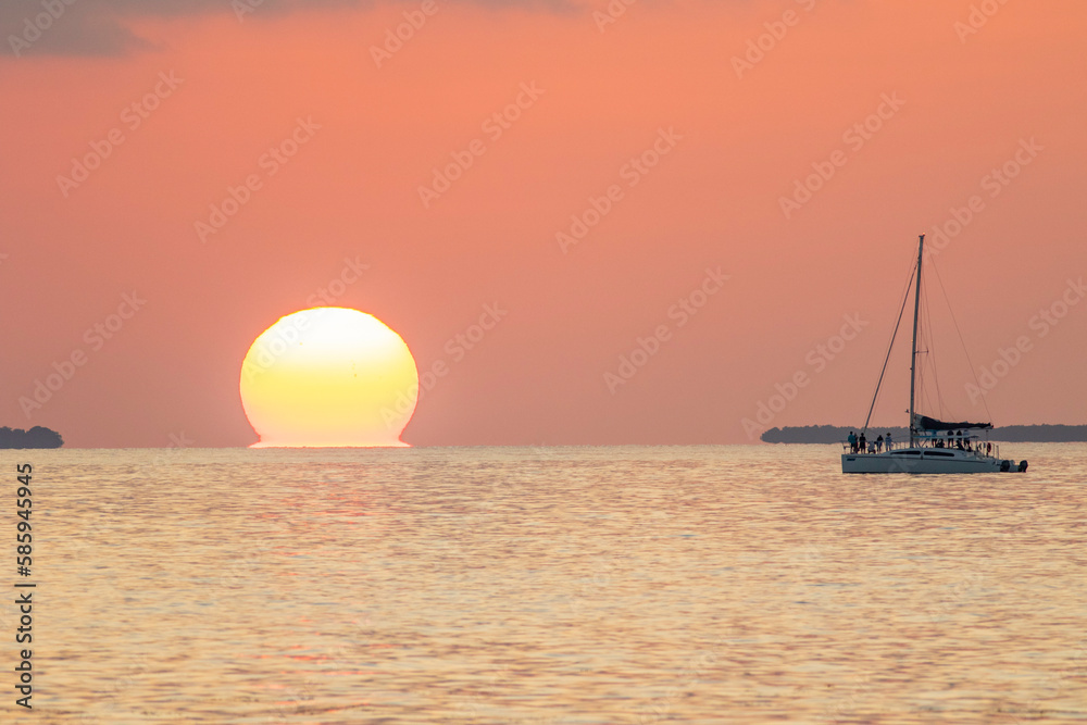 Sun setting in Key West Florida over the ocean with a Catamaran style boat watching. 