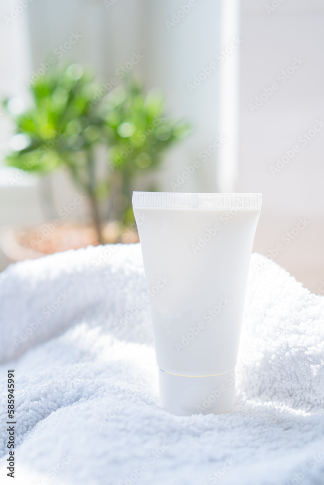 White cream tube and towel in real room interior mock-up, beauty and care product packaging template White cream tube and towel in real room interior mock-up, beauty and care product packaging template