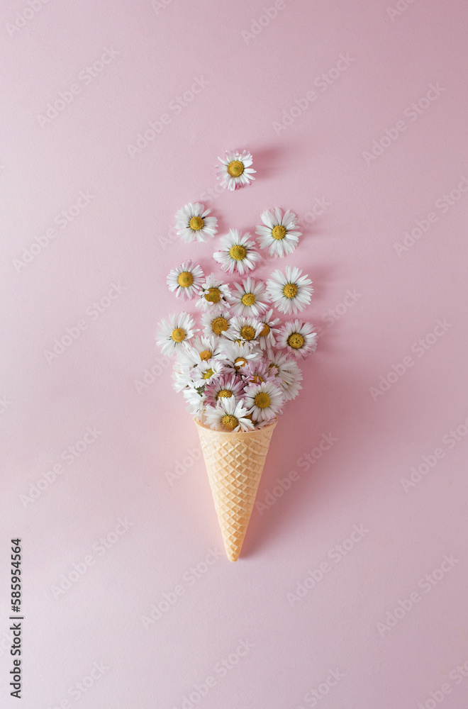 Ice cream cone with daisy flower and leaves on pink background. Flat lay. Minimal summer concept.