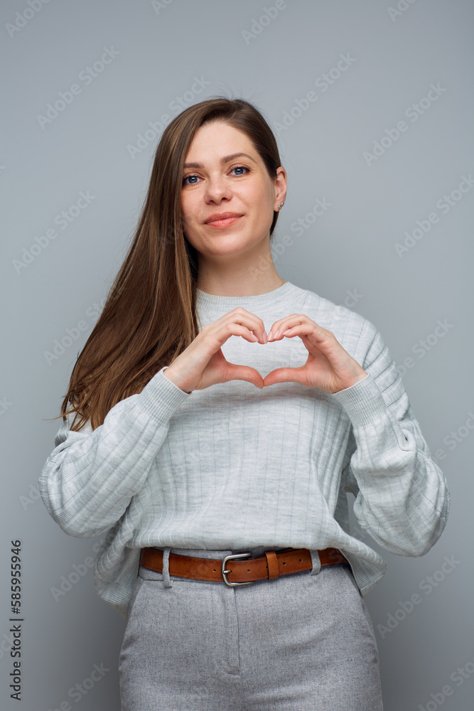 Smiling girl making heart shape with her fingers. Isolated portrait. Smiling girl making heart shape with her fingers. Isolated portrait.