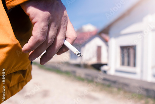 Man holding a cigarette in hand. Man hand with cigarette