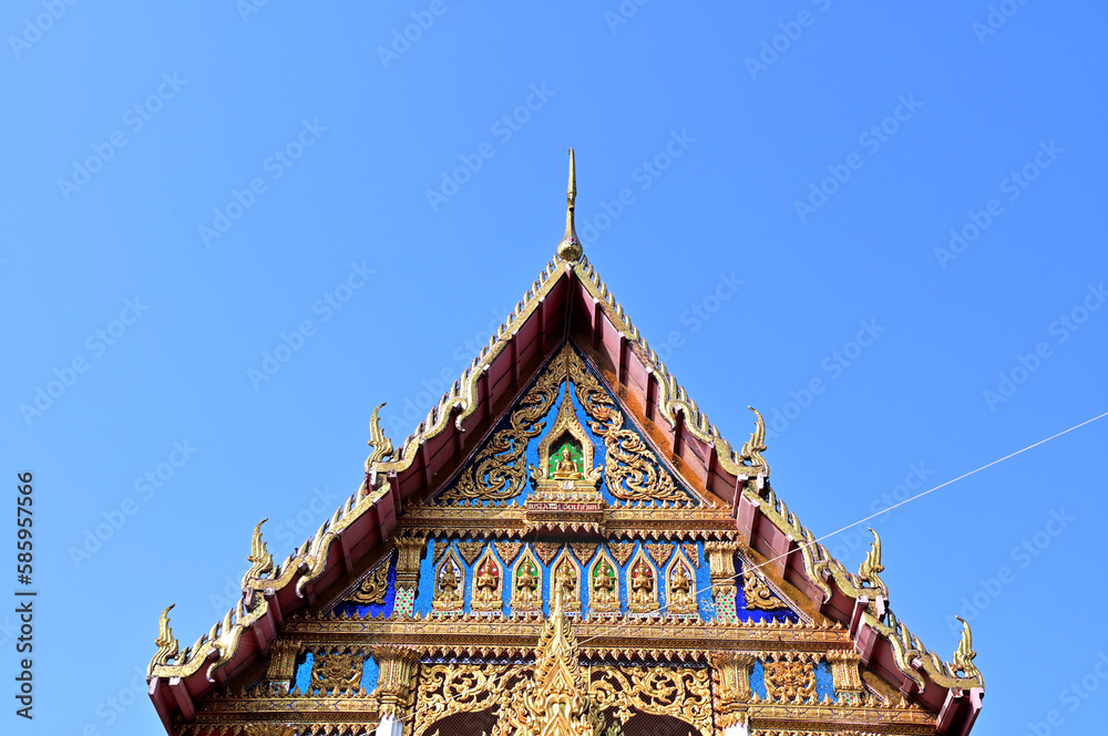BANGKOK, THAILAND - March 29, 2023 : Part of the Roof of a temple in Thailand. Traditional Thai style pattern on the roof of a temple with Blue Sky Background. BANGKOK, THAILAND - March 29, 2023 : Part of the Roof of a temple in Thailand. Traditional Thai style pattern on the roof of a temple with Blue Sky Background.