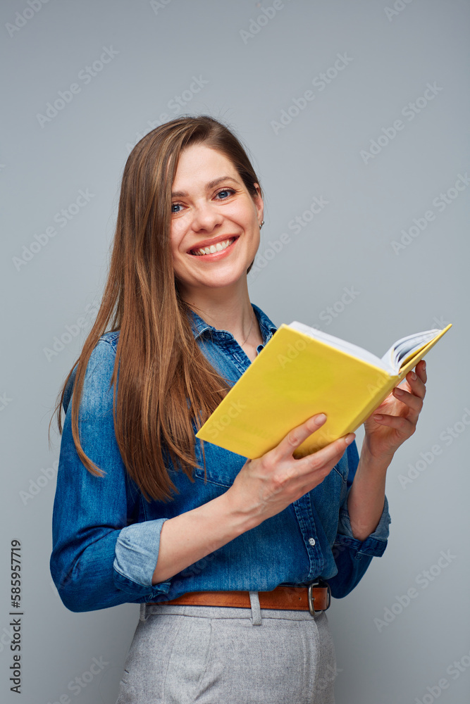 Woman student in blue shirt holding open yellow book. Woman student in blue shirt holding open yellow book.