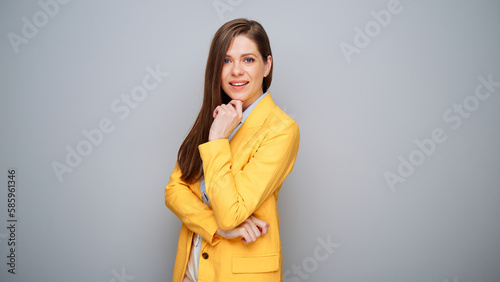 Thinking smart business woman in yellow jacket on gray background.
