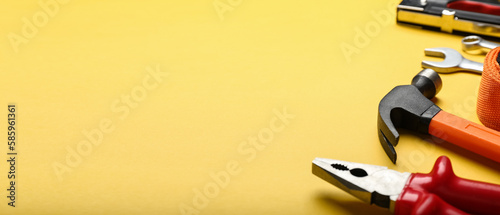 Set of carpenter's tools on yellow background with space for text