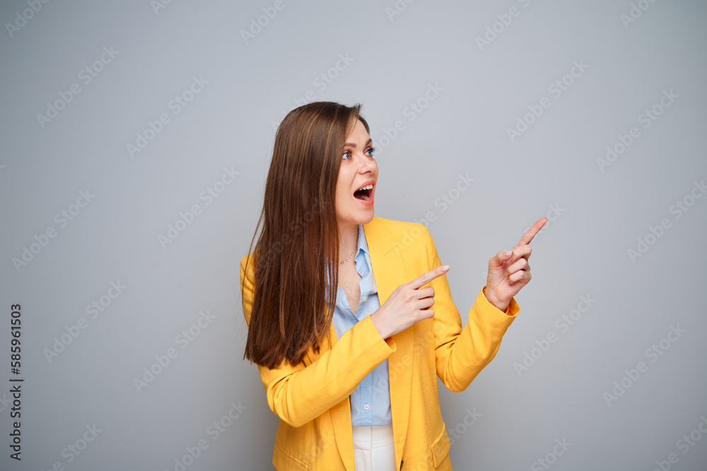 Happy smiling woman in yellow jacket pointing fingers at side. Happy smiling woman in yellow jacket pointing fingers at side.