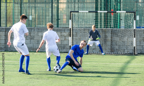Youthful football players challenging for ball in midfield zone © JackF