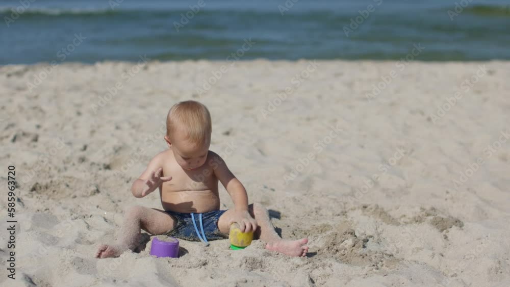 little toddler boy sitting white sandy beach playing colorful plastic molds learning forms and sizes. happy family summer vacations. seaside activity child kid educational games nature. motor skills little toddler boy sitting white sandy beach playing colorful plastic molds learning forms and sizes. happy family summer vacations. seaside activity child kid educational games nature. motor skills