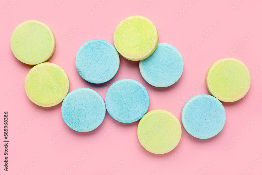 Green and blue soluble tablets on pink background Green and blue soluble tablets on pink background