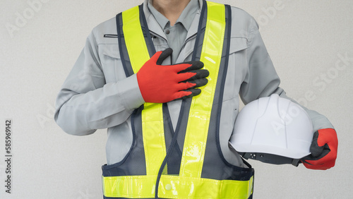 ヘルメットを持つ作業服の男性｜建設業・警備員・ガードマン イメージ