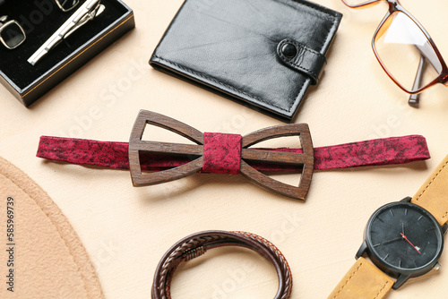 Set of male accessories with stylish bow tie on color background, closeup