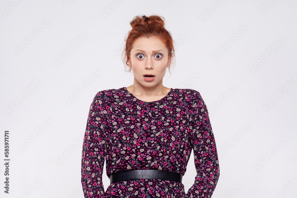 Woman wearing dress looking at camera with mouth open in amazement, expressing shock, astonishment. Woman wearing dress looking at camera with mouth open in amazement, expressing shock, astonishment.