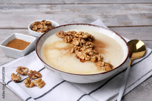 Bowl of tasty semolina porridge with nuts on wooden table