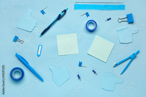 Composition with drawing compass, scotch tape and sticky notes on blue background