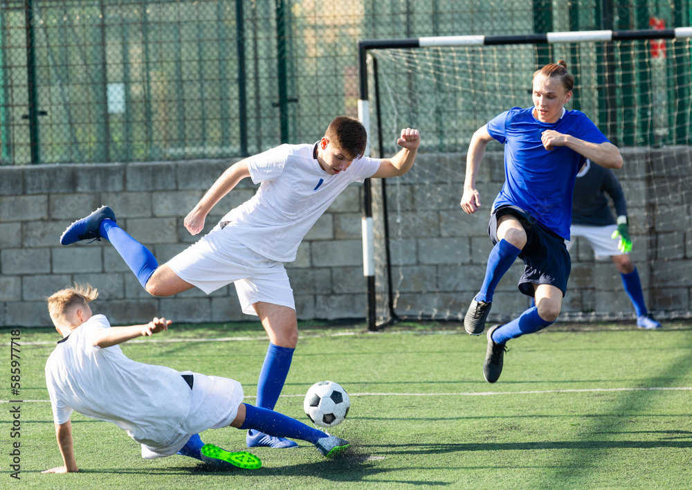 Obraz premium Youth football player kicking ball in direction of goal