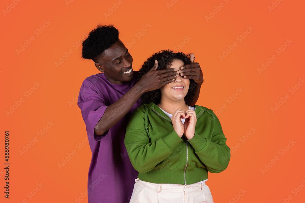 Loving african american guy closing his girlfriends eyes Loving african american guy closing his girlfriends eyes
