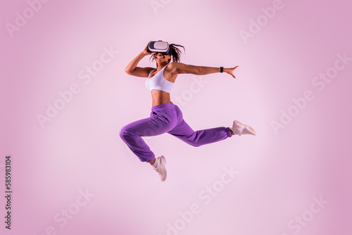 Fotomurale Young black woman working out with 3D technology, jumping while wearing virtual