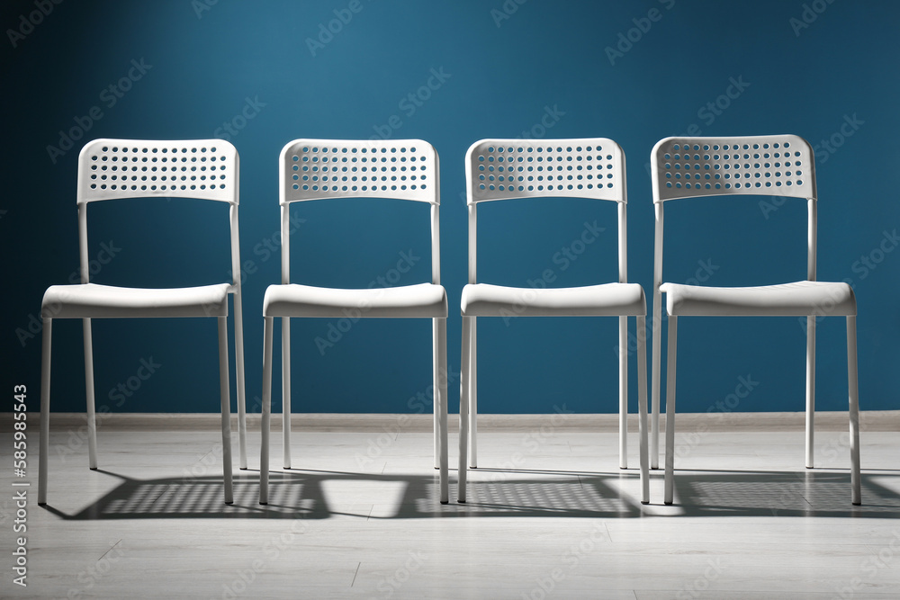 Obraz premium White chairs near blue wall. Recruiter searching employee