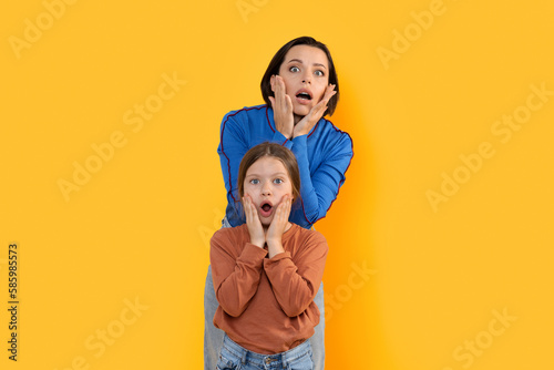 Portrait Of Shocked Mother And Little Daughter Looking At Camera